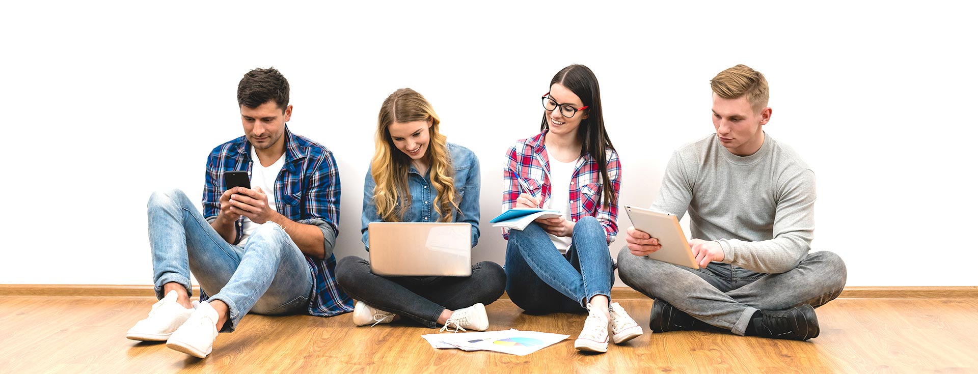 trabaja-con-nosotros Jóvenes trabajando descontracturadamente con computadoras y dispositivos