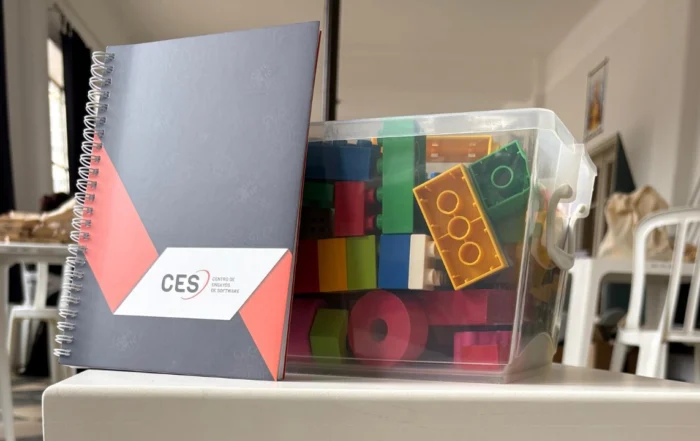 Cuaderno del CES junto a bloques de construcción utilizados en la actividad sobre desarrollo y testing de software.
